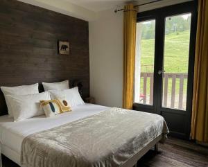 a bedroom with a large bed with a window at Hôtel Chalet Sainte-Anne in Condamine-Châtelard