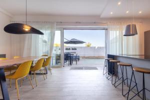 a dining room with yellow chairs and a table at Dar Sara Holiday Home in Victoria