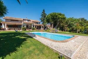 a house with a swimming pool in front of a yard at Beachfront villa with direct access -Private pool & Zen Area in Quartu SantʼElena