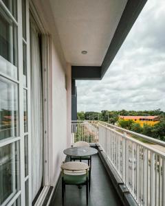 a balcony with a table and chairs and a window at Atmosfera Bengaluru, India in Bangalore