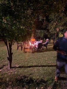 a group of people sitting around a fire in a park at Bajoon homestay in Bhīm Tāl