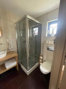 a bathroom with a shower and a toilet and a sink at Domki Norda in Władysławowo +7 photos