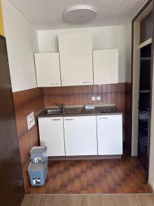 a kitchen with white cabinets and a trash can at Sara`s Guesthouse Bled in Bled