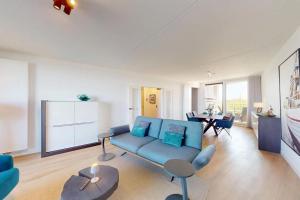 a living room with a blue couch and a table at Port Scaldis 05-012 in Breskens