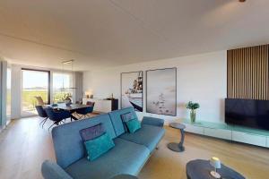 a living room with a blue couch and a television at Port Scaldis 05-012 in Breskens