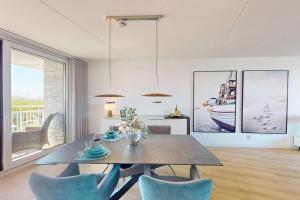 a dining room with a table and blue chairs at Port Scaldis 05-012 in Breskens +17 photos