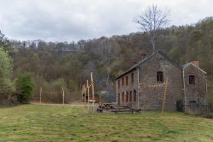 an old brick building with a picnic table in a field at Maison de la Turbine in Yvoir