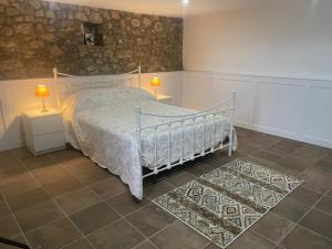 a bedroom with a bed and two lamps on two tables at Casa Borboleta in Chão de Lamas