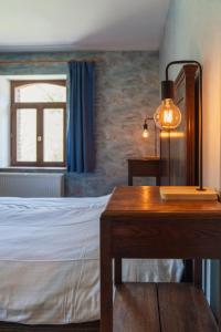 a bedroom with a bed and a desk and a window at Maison de la Turbine in Yvoir