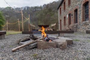 a fire pit in front of a brick building at Maison de la Turbine in Yvoir +7 photos