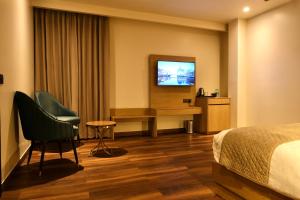 a hotel room with a bed and a television at Red Sapphire Royale in Morādābād