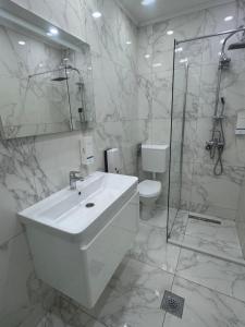 a white bathroom with a sink and a shower at Motel Marco Polo in Gredice +24 photos