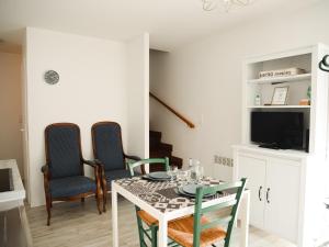 a dining room with a white table and chairs at LE REPOS DU VOYAGEUR T3 45 m2 tout confort in Lussac-les-Châteaux