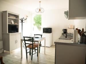 a kitchen with a table and chairs in a kitchen at LE REPOS DU VOYAGEUR T3 45 m2 tout confort in Lussac-les-Châteaux