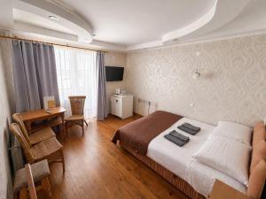 a bedroom with a bed and a desk in a room at SPA Villa Jasmin in Truskavets