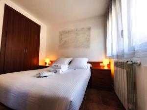 a bedroom with two beds and a window and two lamps at AC Apartaments Cabirol Incles in Incles