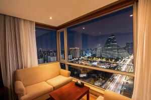 a room with a couch and a view of a city at Pumpkin Hotel in Beijing