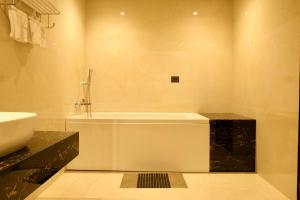 a bathroom with a bath tub and a sink at Red Sapphire Royale in Morādābād +27 photos