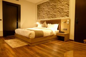 a bedroom with a bed with a large painting on the wall at Red Sapphire Royale in Morādābād