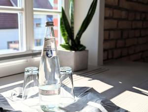a bottle of water sitting on a table with two glasses at II Bramasole - La Contessa in Spreewitz