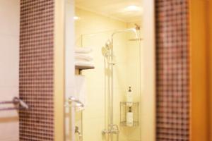 a bathroom with a shower with white towels at Pumpkin Hotel in Beijing +54 photos