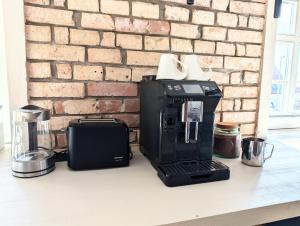 a coffee maker on a counter next to a brick wall at II Bramasole - La Contessa in Spreewitz +33 photos
