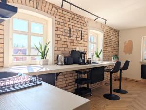 a kitchen with a brick wall and a counter with stools at II Bramasole - La Contessa in Spreewitz