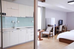 a kitchen and a bedroom with a bed and a table at Pumpkin Hotel in Beijing
