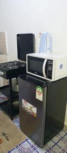 a microwave sitting on top of a refrigerator at Chaka homes 2 bedroom in Kiganjo