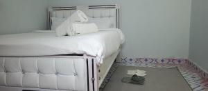 a white bed with white sheets and pillows on it at Chaka homes 2 bedroom in Kiganjo