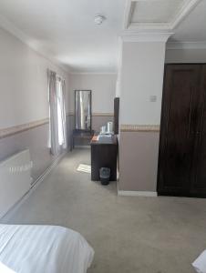 a bedroom with a bed and a desk and a mirror at The Bell Hotel in Mildenhall