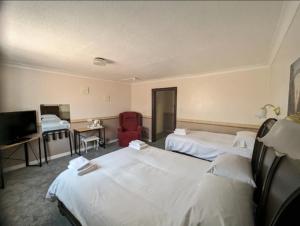 a hotel room with two beds and a television at The Bell Hotel in Mildenhall