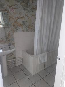 a bathroom with a bath tub and a shower curtain at The Bell Hotel in Mildenhall