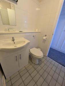 a white bathroom with a toilet and a sink at The Bell Hotel in Mildenhall +55 photos