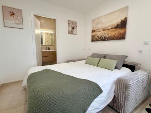 a bedroom with a large white bed in a room at Cosy studio with garden in Chevry