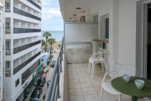a balcony with a table and chairs and a view of the ocean at Larnaca Bay Suites in Larnaca