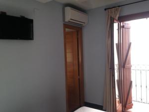Zimmer mit einem TV und einer Tür mit einem Fenster in der Unterkunft Hostal Aranda in Peñíscola