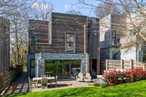 a wooden house with a patio in the yard at House 6 in Looe