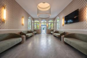 a waiting room with couches and a flat screen tv at Hotel Astoria Garden in Rome