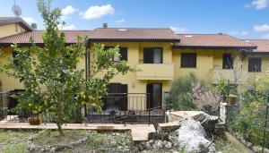 a yellow house with a fence in front of it at Villa Mare Monti in Maranola
