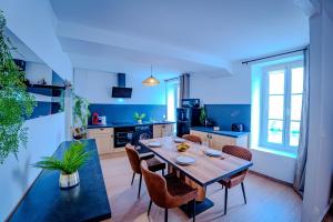 a kitchen and dining room with a table and chairs at TEMPLE JACQUESSON - Gare - Centre ville - WIFI RAPIDE et STREAMING - PARKING GRATUIT - CHECK IN 24H - CLIMATISATION - IDEAL PROS - cour privée - barbecue in Chalons en Champagne