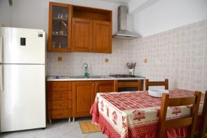 a kitchen with a table and a white refrigerator at Villa Mare Monti in Maranola