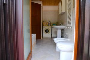 a bathroom with two toilets and a sink and a washing machine at Villa Mare Monti in Maranola +50 photos