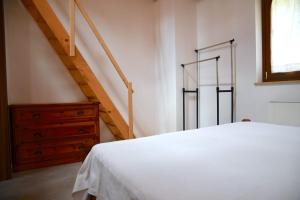 a bedroom with a white bed and a staircase at Villa Mare Monti in Maranola
