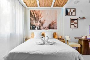 two swans sitting on a bed in a bedroom at YourSuite Studio Premium à Thème in Chaville +84 photos