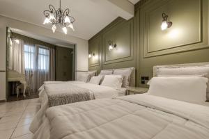 a bedroom with two beds and a chandelier at Alsos House in Kalabaka