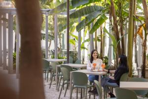 two women sitting at tables in a restaurant at Hotel Astoria Garden in Rome