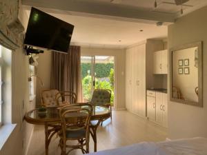 a living room with a table and chairs and a kitchen at Maroela House Guest Accommodation in Bellville