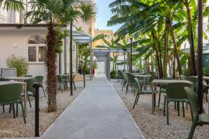 a restaurant with tables and chairs and palm trees at Hotel Astoria Garden in Rome