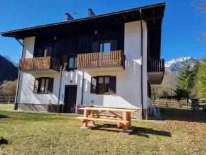 a house with a picnic table in front of it at Casa Pineta in Ledro